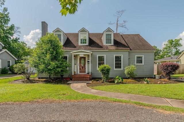 2635 Gladys Ave, Beaumont, TX 77701 - cape cod home with a chimney, a shingled roof, and a front yard