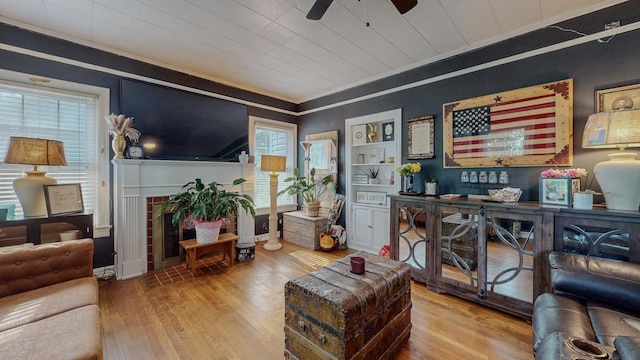 2635 Gladys Ave, Beaumont, TX 77701 - living area with a tile fireplace, crown molding, a ceiling fan, baseboards, and wood finished floors
