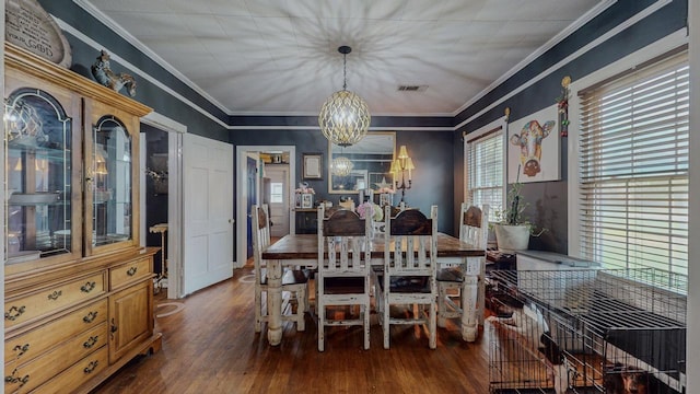 2635 Gladys Ave, Beaumont, TX 77701 - dining room featuring crown molding, an inviting chandelier, visible vents, and wood finished floors