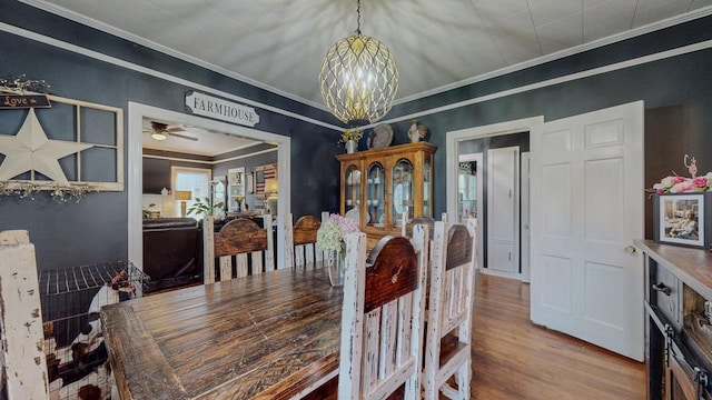 2635 Gladys Ave, Beaumont, TX 77701 - dining room with wood finished floors, ceiling fan with notable chandelier, and crown molding