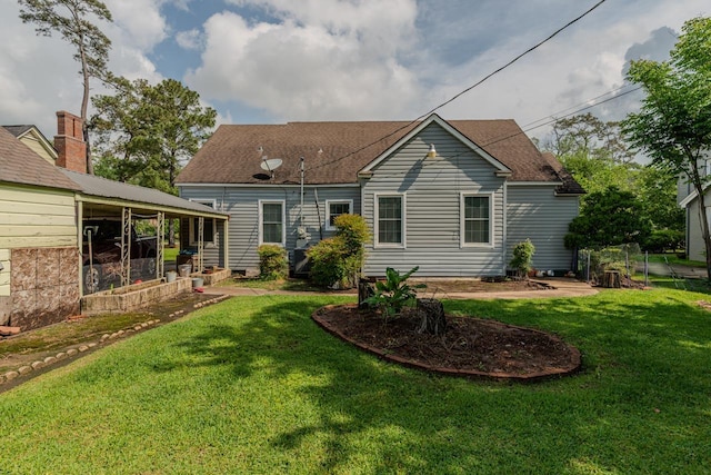2635 Gladys Ave, Beaumont, TX 77701 - rear view of property featuring a shingled roof and a lawn