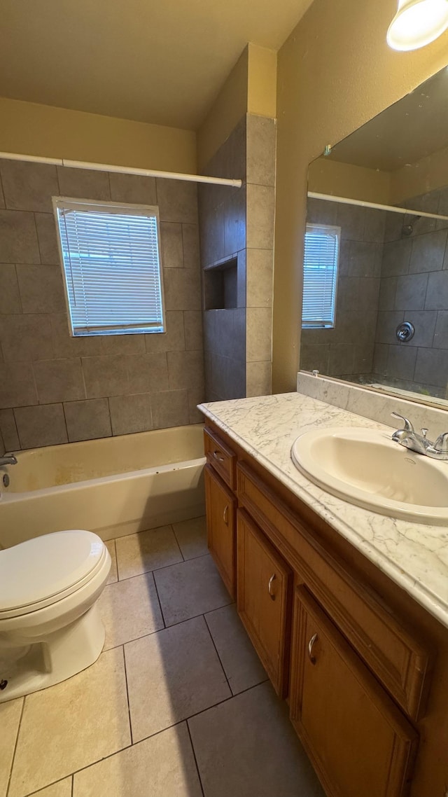 full bathroom with tiled shower / bath combo, vanity, a wealth of natural light, tile patterned floors, and toilet