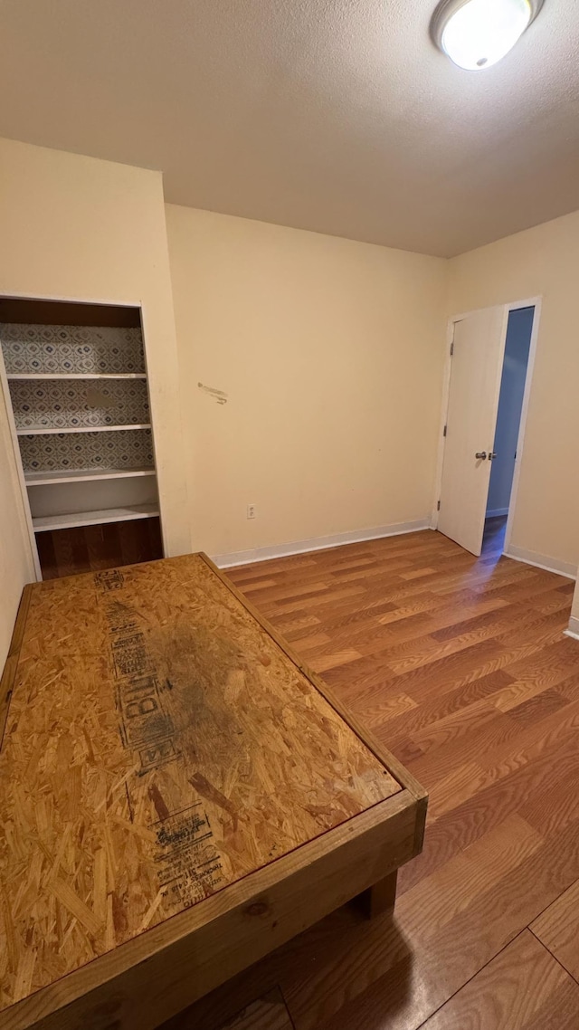 spare room featuring hardwood / wood-style floors and a textured ceiling