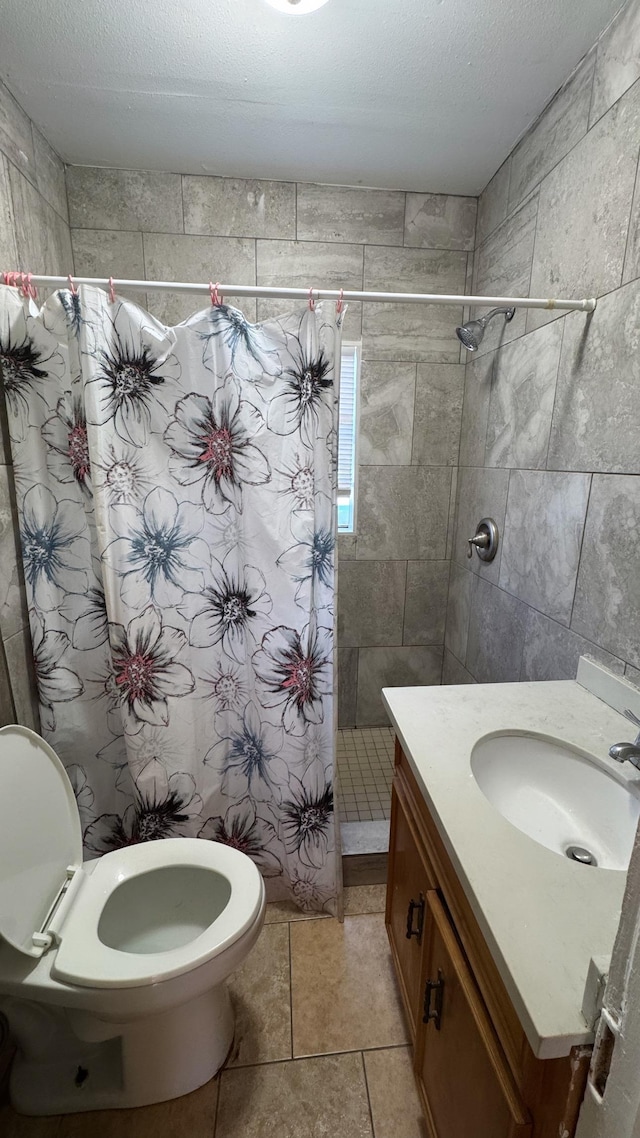 bathroom with tile patterned floors, toilet, a shower with curtain, a textured ceiling, and vanity