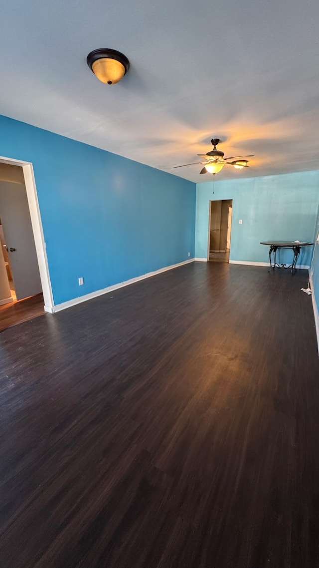 unfurnished living room with ceiling fan and dark hardwood / wood-style flooring