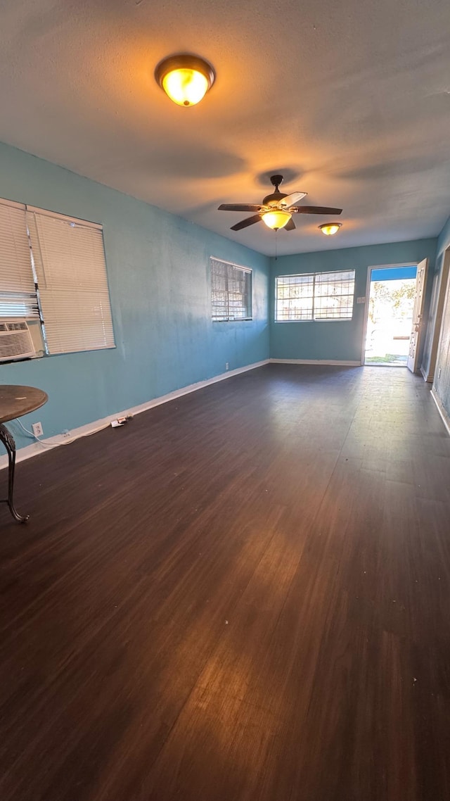 unfurnished room featuring cooling unit, ceiling fan, dark hardwood / wood-style floors, and a textured ceiling