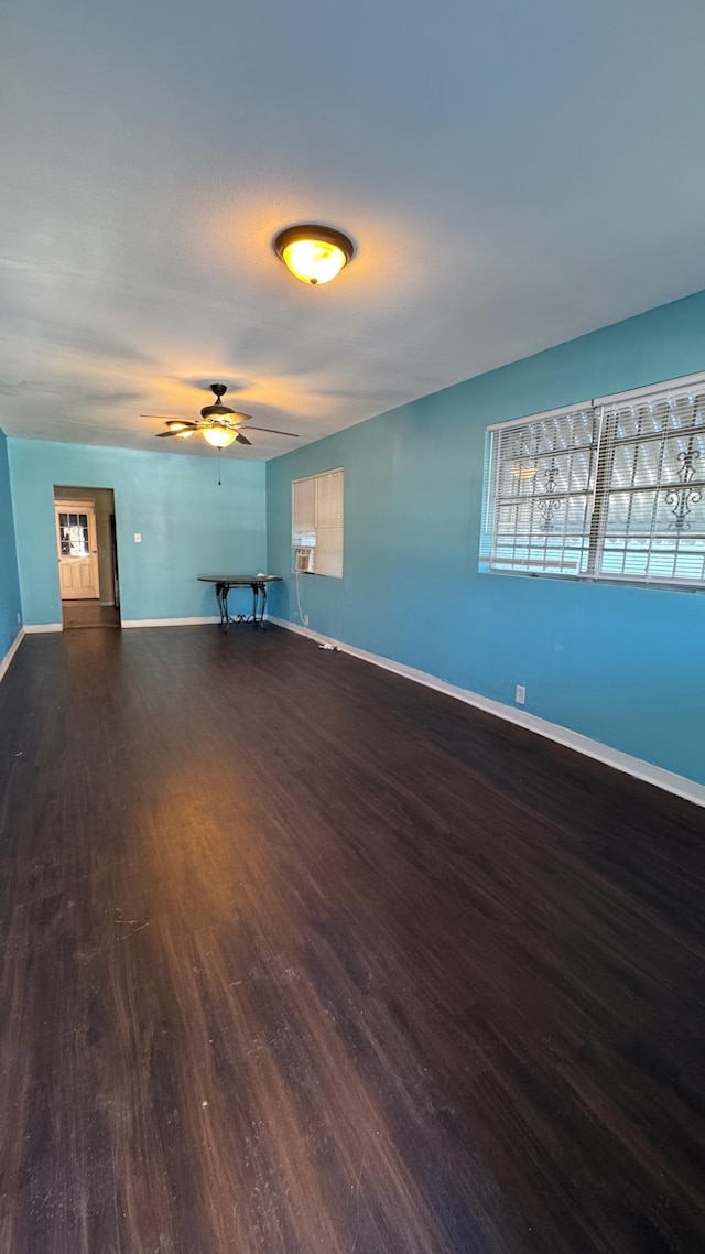 empty room featuring dark wood-type flooring and ceiling fan