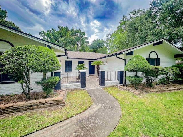 3640 Whippoorwill St, Orange, TX 77630 - view of front facade with brick siding, a fenced front yard, and a gate