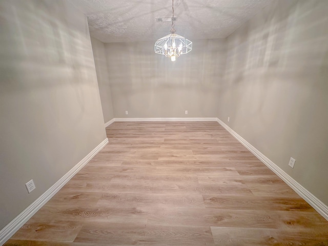 3640 Whippoorwill St, Orange, TX 77630 - unfurnished dining area featuring a chandelier, light wood finished floors, and a textured ceiling