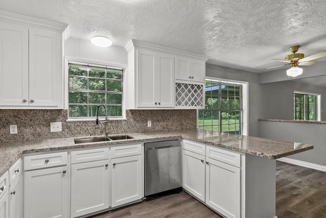 3640 Whippoorwill St, Orange, TX 77630 - kitchen with stainless steel dishwasher, a peninsula, dark wood-type flooring, white cabinetry, and a textured ceiling