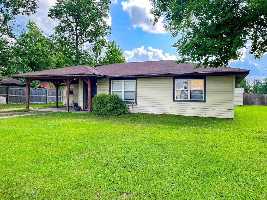 495 Woodland, Vidor, TX 77662 - ranch-style house with fence, a front yard, and an attached carport