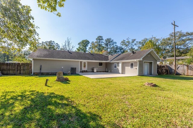 rear view of house featuring a lawn, a patio, and central AC