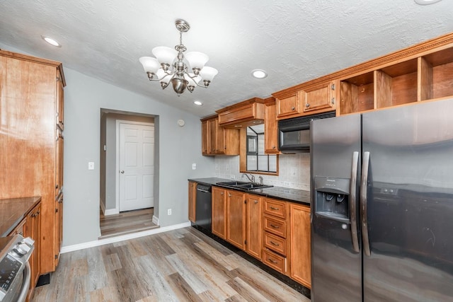 kitchen featuring sink, an inviting chandelier, decorative light fixtures, decorative backsplash, and black appliances