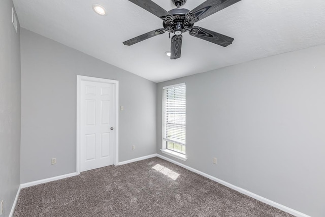 empty room with carpet flooring, ceiling fan, and vaulted ceiling