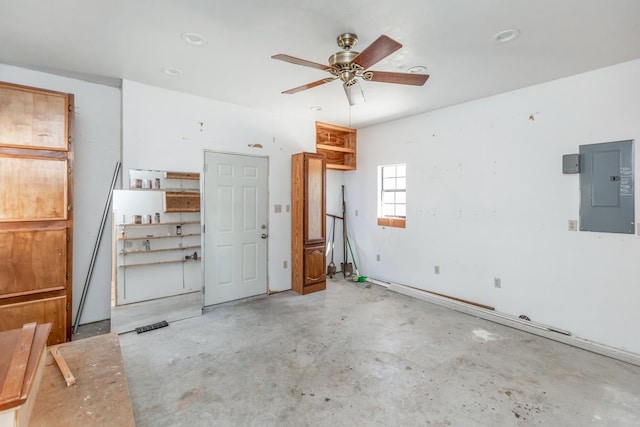 interior space featuring electric panel, ceiling fan, and concrete flooring