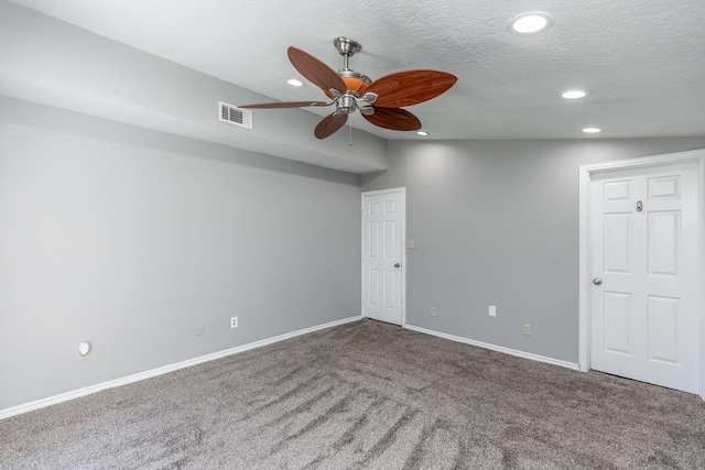 spare room featuring vaulted ceiling, ceiling fan, carpet floors, and a textured ceiling