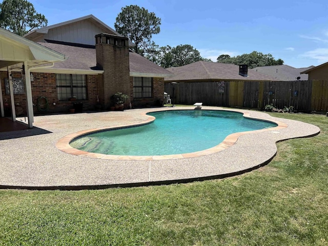 view of swimming pool with a patio area and a yard