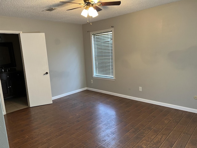 empty room featuring a textured ceiling, ceiling fan, and dark hardwood / wood-style floors