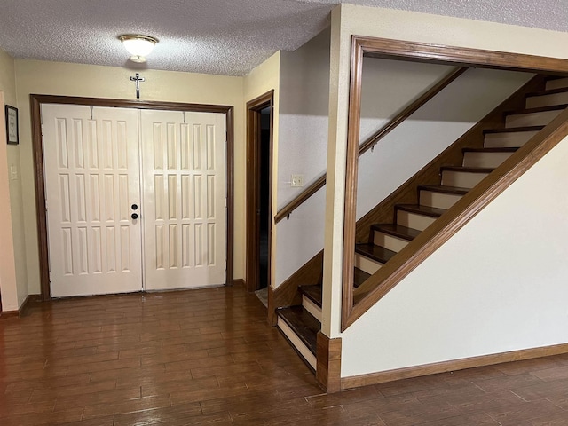 foyer with a textured ceiling and dark hardwood / wood-style floors