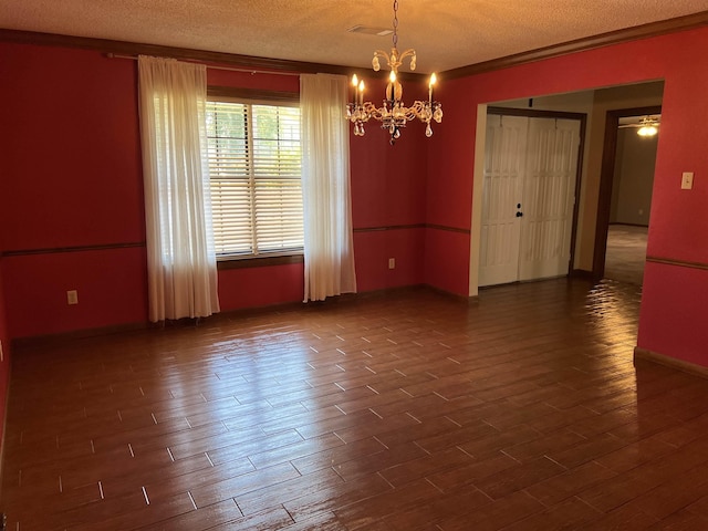 empty room with ceiling fan with notable chandelier, a textured ceiling, and ornamental molding