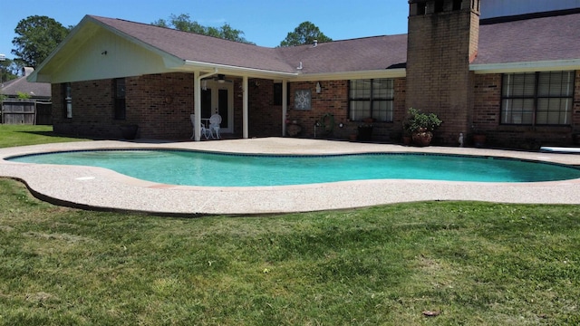 view of pool featuring ceiling fan, a patio area, and a lawn