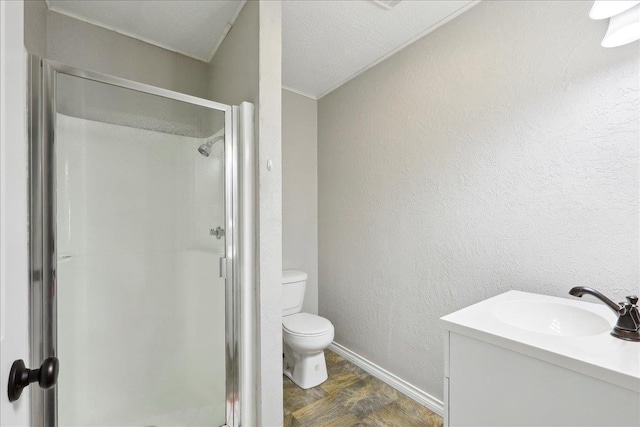 bathroom featuring a shower with door, vanity, and toilet