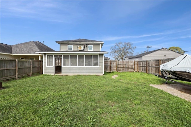 rear view of house featuring a sunroom and a lawn