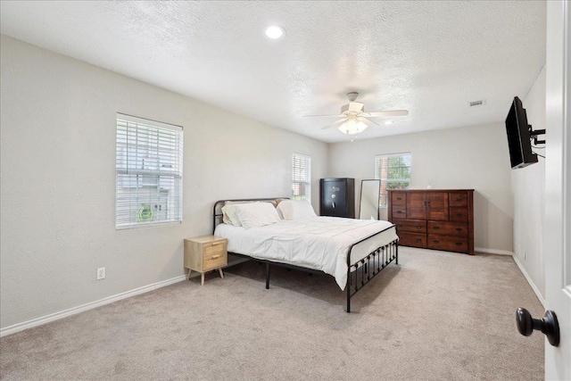 carpeted bedroom with ceiling fan and a textured ceiling