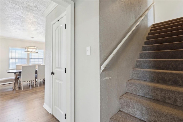 stairs with hardwood / wood-style floors and a textured ceiling