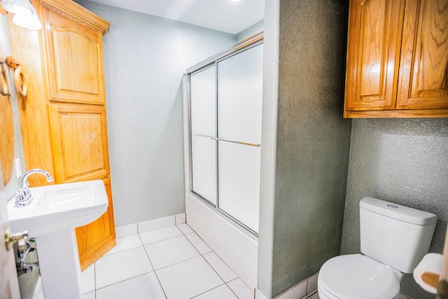 full bathroom featuring sink, toilet, shower / bath combination with glass door, and tile patterned flooring