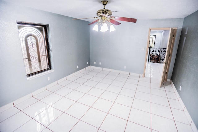 unfurnished room with ceiling fan and light tile patterned flooring