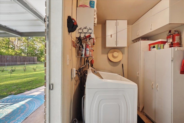 laundry area featuring washer / dryer and cabinet space