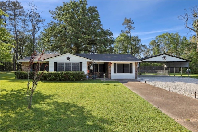 ranch-style home featuring a detached carport, gravel driveway, a front lawn, and fence
