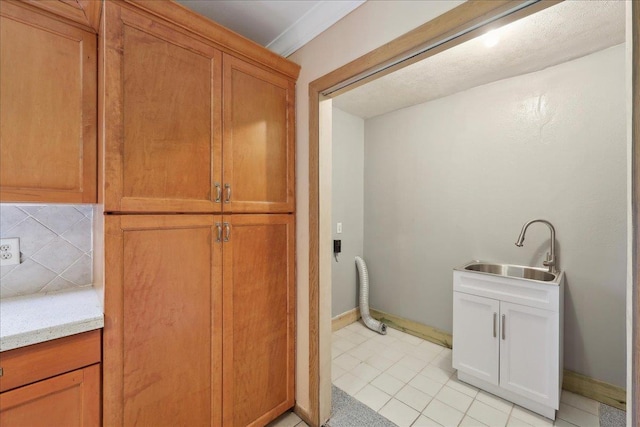 1035 Chamberlin Dr, Beaumont, TX 77707 - laundry room with light tile patterned floors, baseboards, laundry area, and a sink