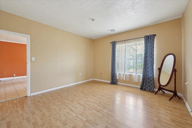 1035 Chamberlin Dr, Beaumont, TX 77707 - unfurnished room featuring a textured ceiling, visible vents, light wood-style flooring, and baseboards