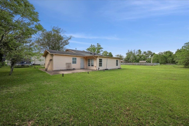 1035 Chamberlin Dr, Beaumont, TX 77707 - rear view of house with a lawn, fence, a trampoline, and a patio area