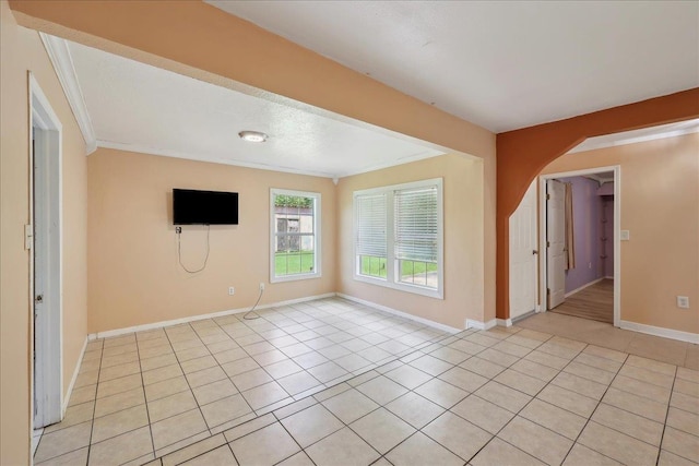1035 Chamberlin Dr, Beaumont, TX 77707 - empty room featuring light tile patterned floors, crown molding, arched walkways, and baseboards