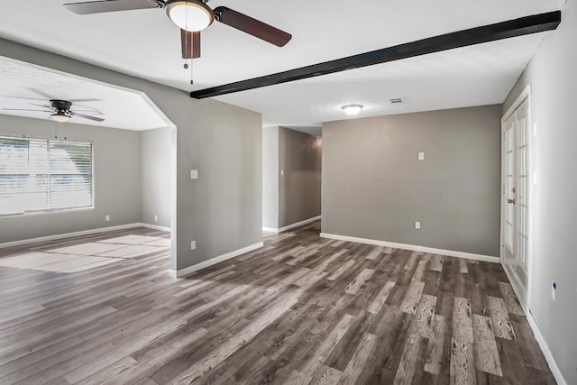 unfurnished living room featuring ceiling fan, beamed ceiling, and dark hardwood / wood-style floors