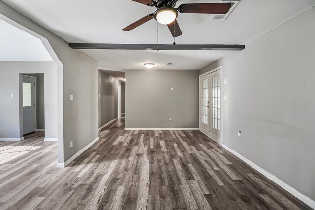 spare room featuring beam ceiling, ceiling fan, french doors, and dark wood-type flooring