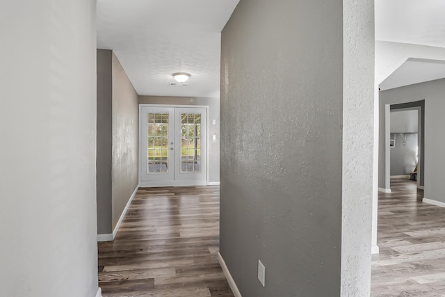 hall with french doors and hardwood / wood-style flooring