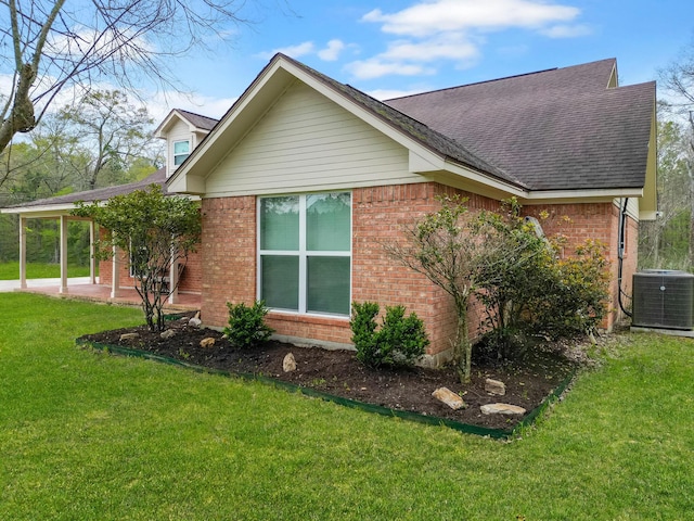310 Medford Ln, Vidor, TX 77662 - view of side of home with central AC unit, brick siding, a shingled roof, and a yard