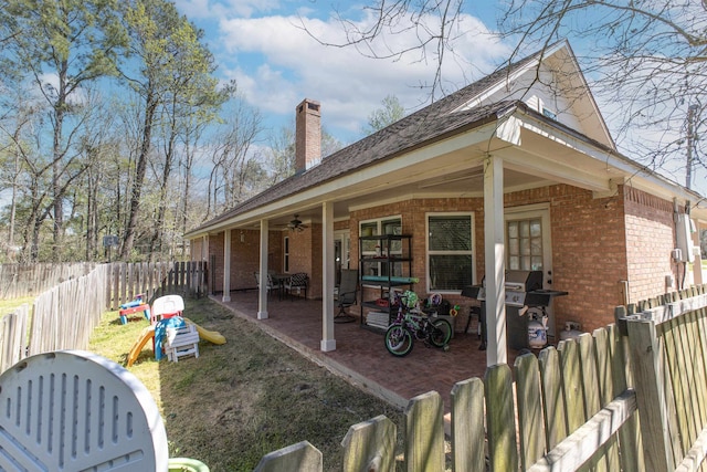 310 Medford Ln, Vidor, TX 77662 - back of property with brick siding, a chimney, a fenced backyard, and a patio area