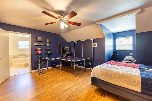 310 Medford Ln, Vidor, TX 77662 - bedroom featuring lofted ceiling, a textured ceiling, light wood finished floors, ceiling fan, and ensuite bathroom