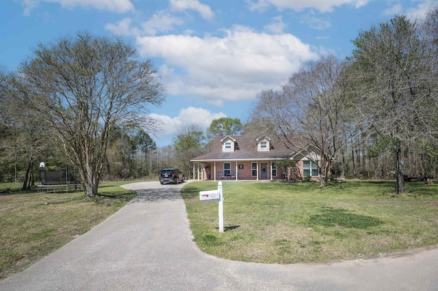 310 Medford Ln, Vidor, TX 77662 - view of front of home with driveway, a front yard, brick siding, and a trampoline