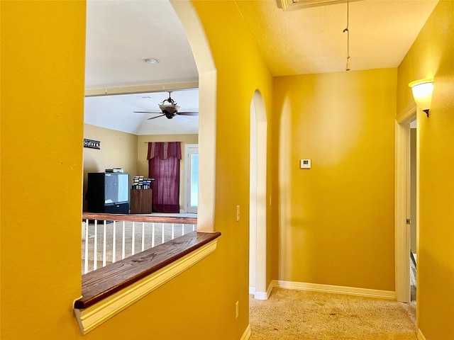 hall with light colored carpet and lofted ceiling