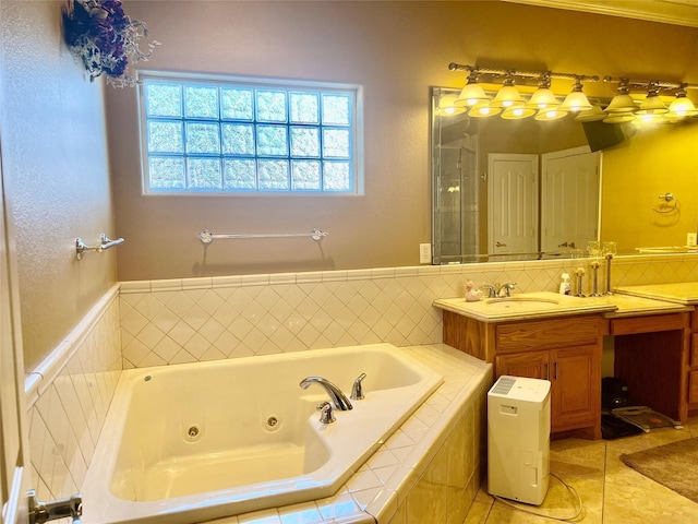 bathroom with tile patterned floors, tiled bath, and vanity