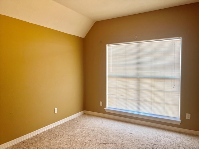 spare room with lofted ceiling and carpet floors