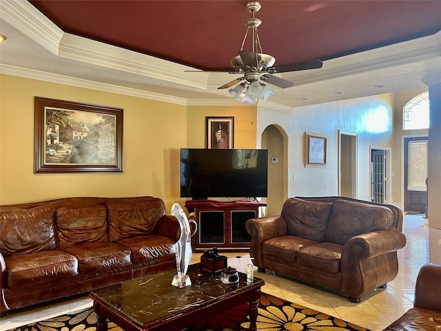 tiled living room featuring ceiling fan, ornamental molding, and a tray ceiling