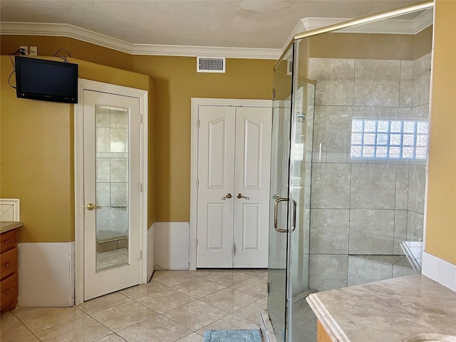 bathroom with vanity, tile patterned floors, a shower with door, and ornamental molding