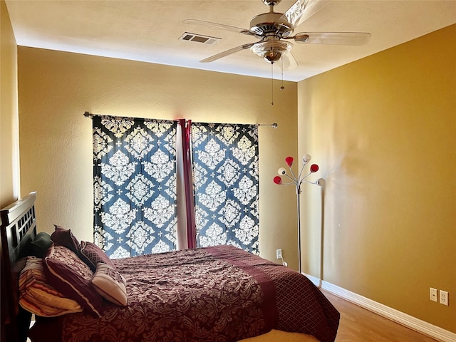 bedroom with ceiling fan and wood-type flooring